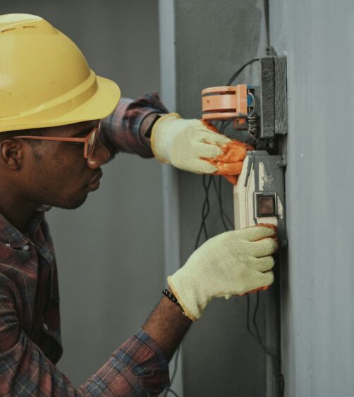 man in brown hat holding black and gray power tool