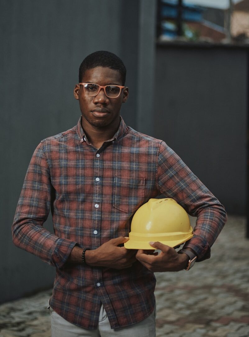 man in blue red and white plaid dress shirt holding yellow plastic bowl